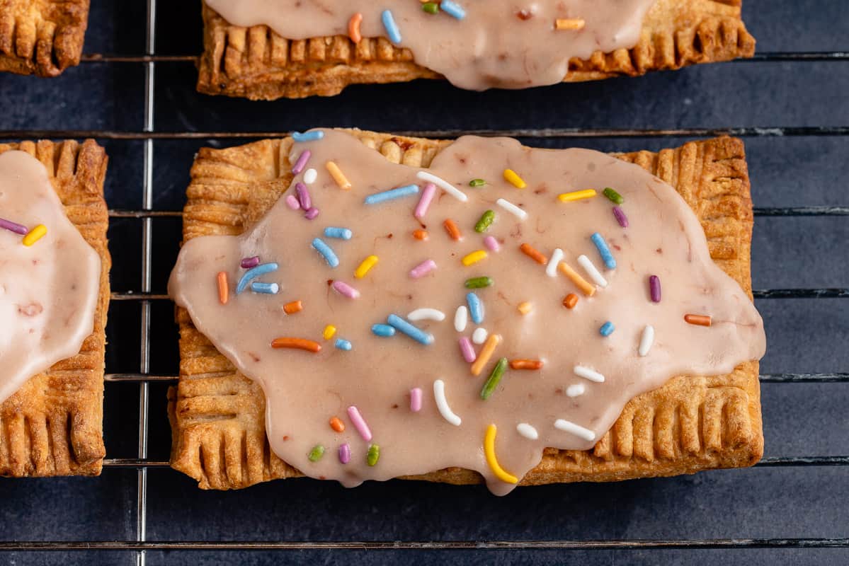 overhead photo of 2 vegan pop tarts with pink icing and sprinkles
