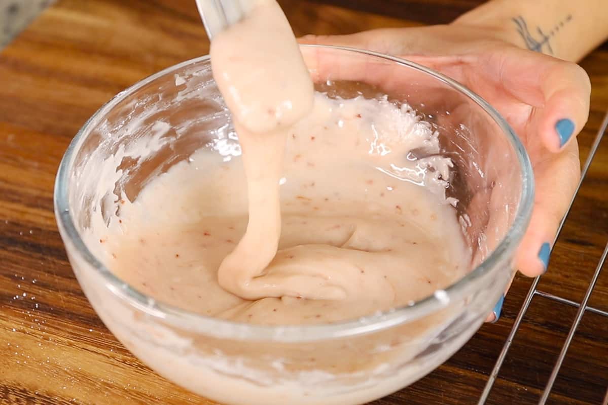 mixing strawberry icing in a glass bowl