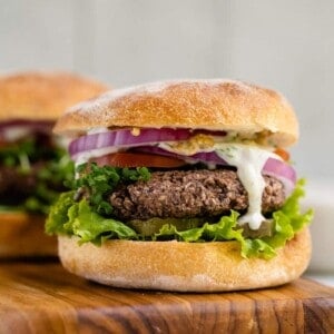 vegan black bean burger with lettuce, tomato, onions, and tzatziki sauce