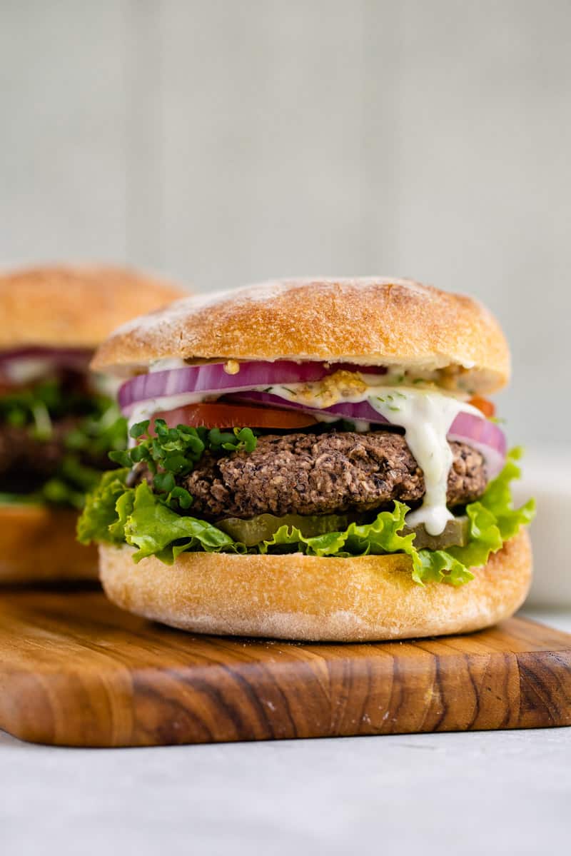 vegan black bean burger with lettuce, tomato, onions, and tzatziki sauce