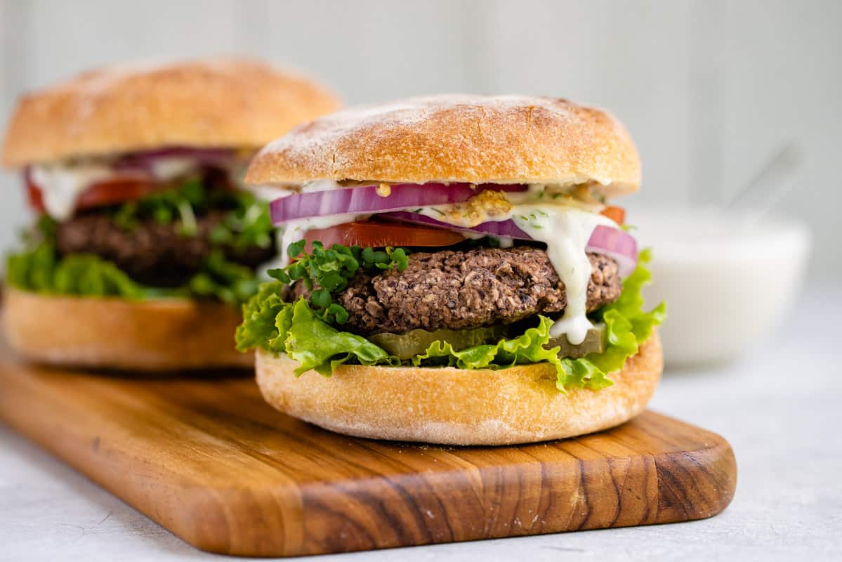 vegan black bean burger with lettuce, tomato, onions, and tzatziki sauce