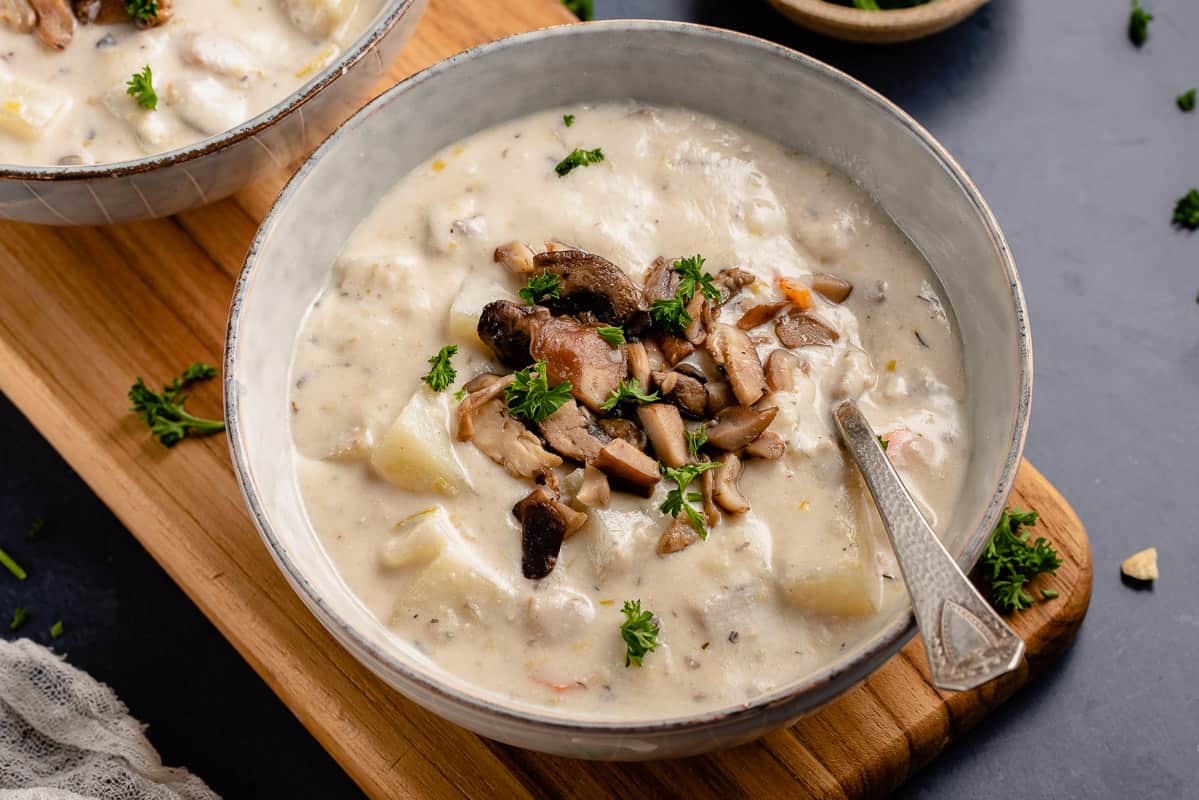 horizontal photo vegan clam chowder in gray bowl with spoon and parsley