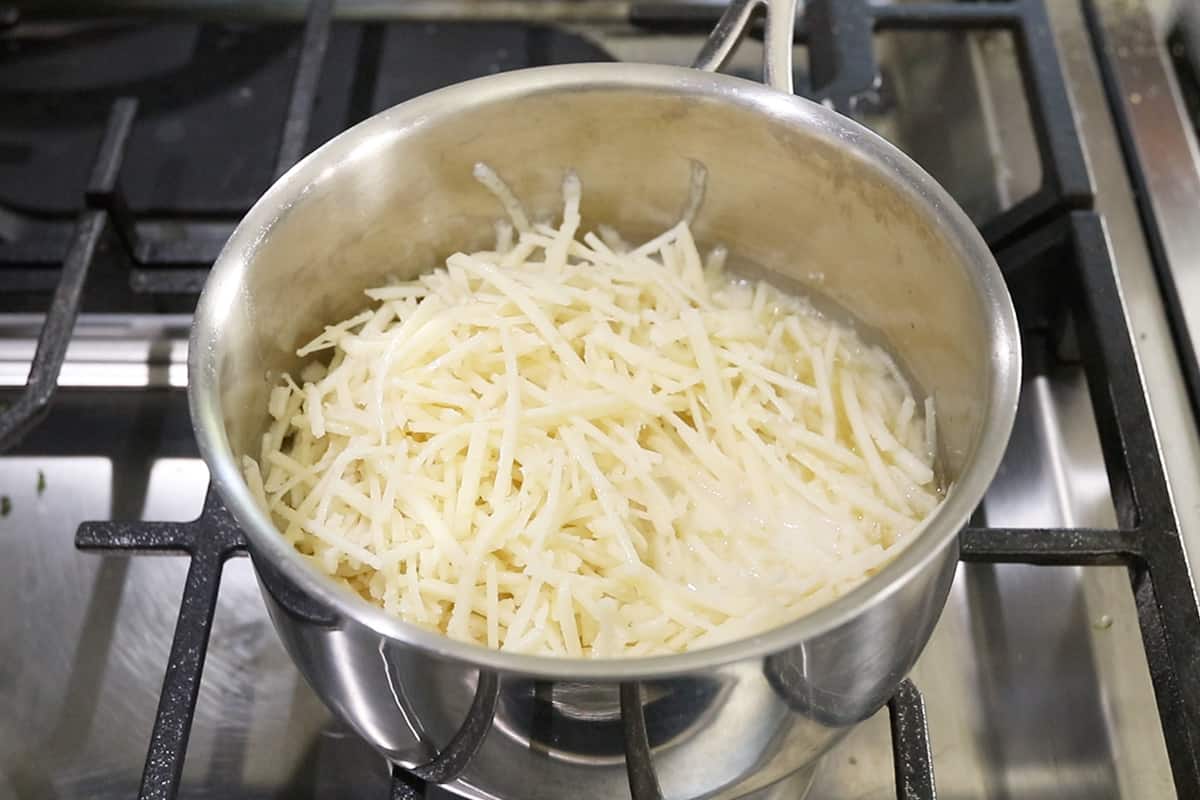 melting vegan cheese in stainless steel pot