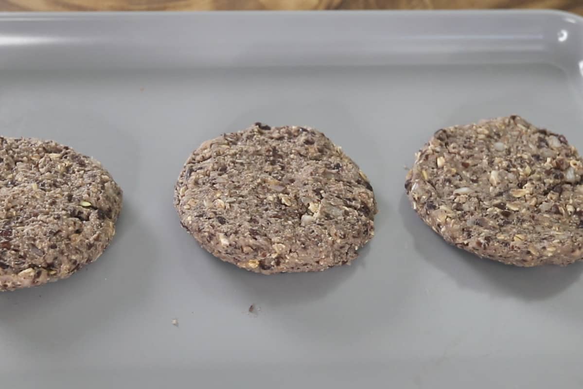 uncooked black bean burgers on a nonstick baking sheet