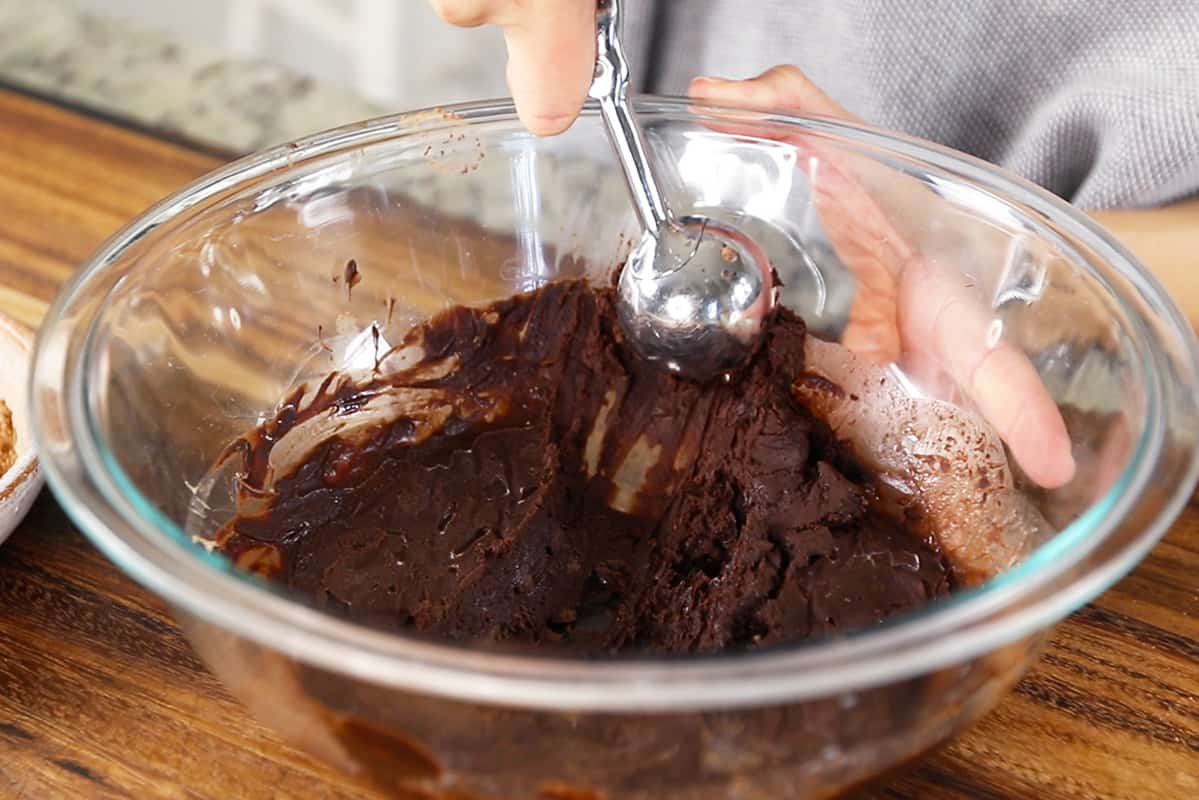 scooping chocolate truffle dough in glass bowl