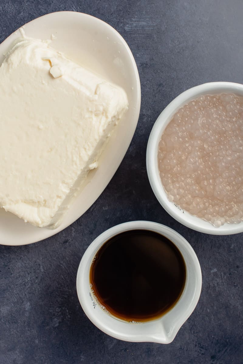 blue table with steamed soft tofu, cooked tapioca pearls and arnibal syrup for taho