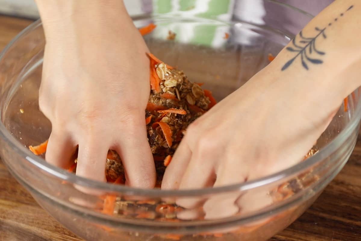 mixing carrot cake bars with hands