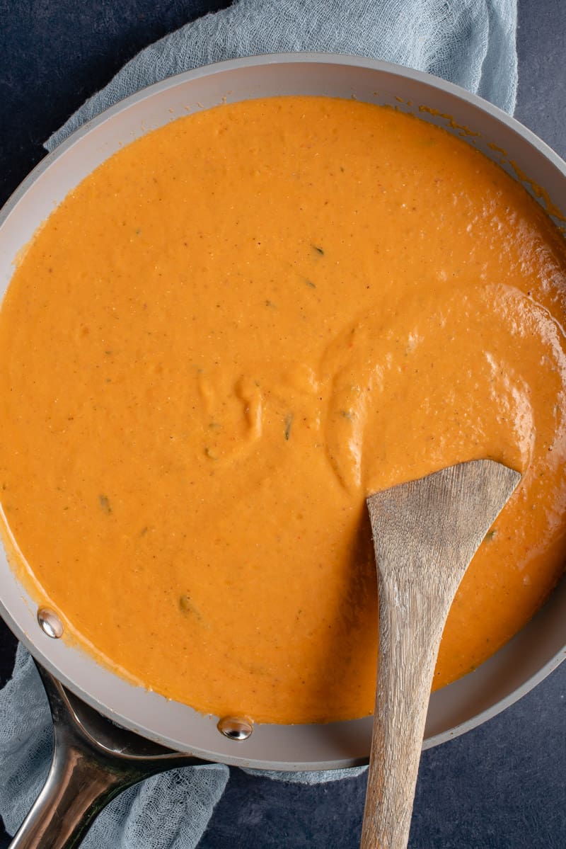 roasted red pepper sauce in pan with wooden spoon