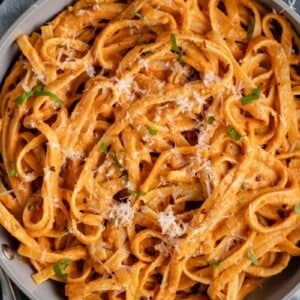 roasted red pepper sauce fettuccine in pot with parmesan and basil