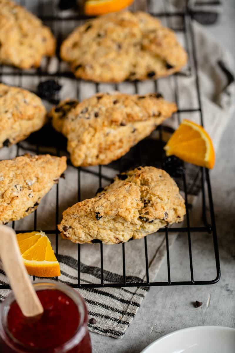 dried chocolate cherry scones on cooling rack with strawberry jam