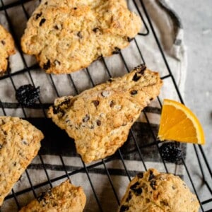 dried chocolate cherry scones on cooling rack with orange pieces
