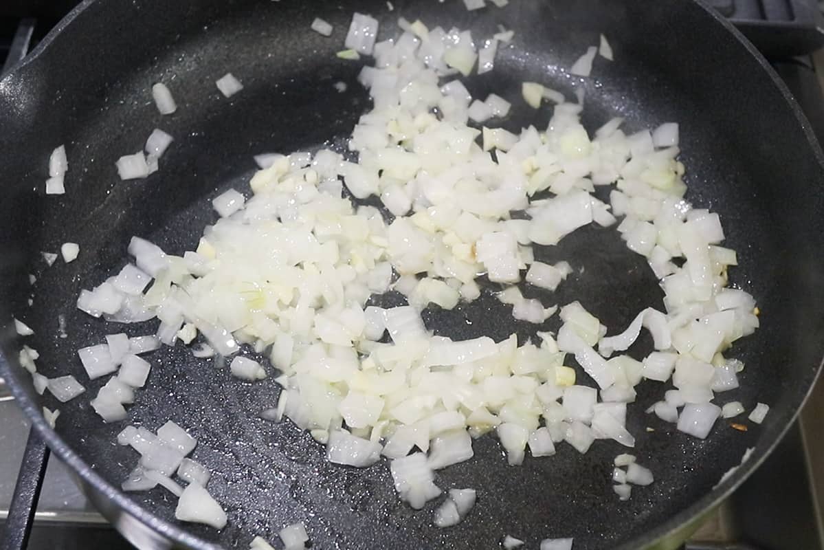 sautéing onions in black pan with oil