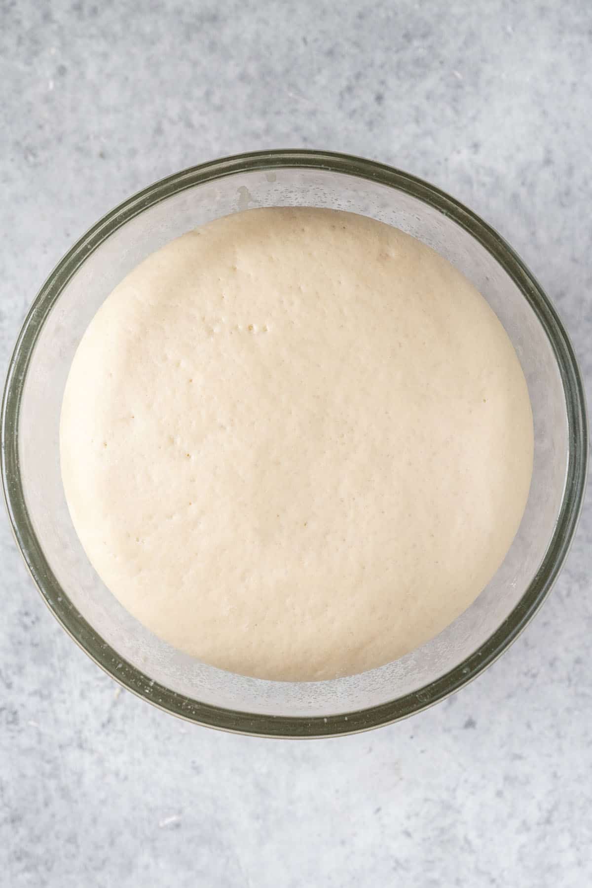risen pita bread dough in glass bowl