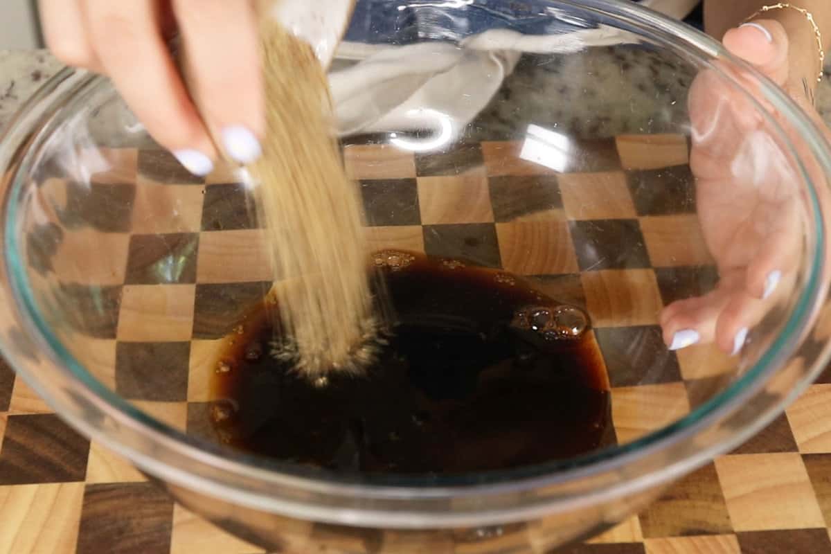 adding flaxseed meal to soy sauce in glass bowl