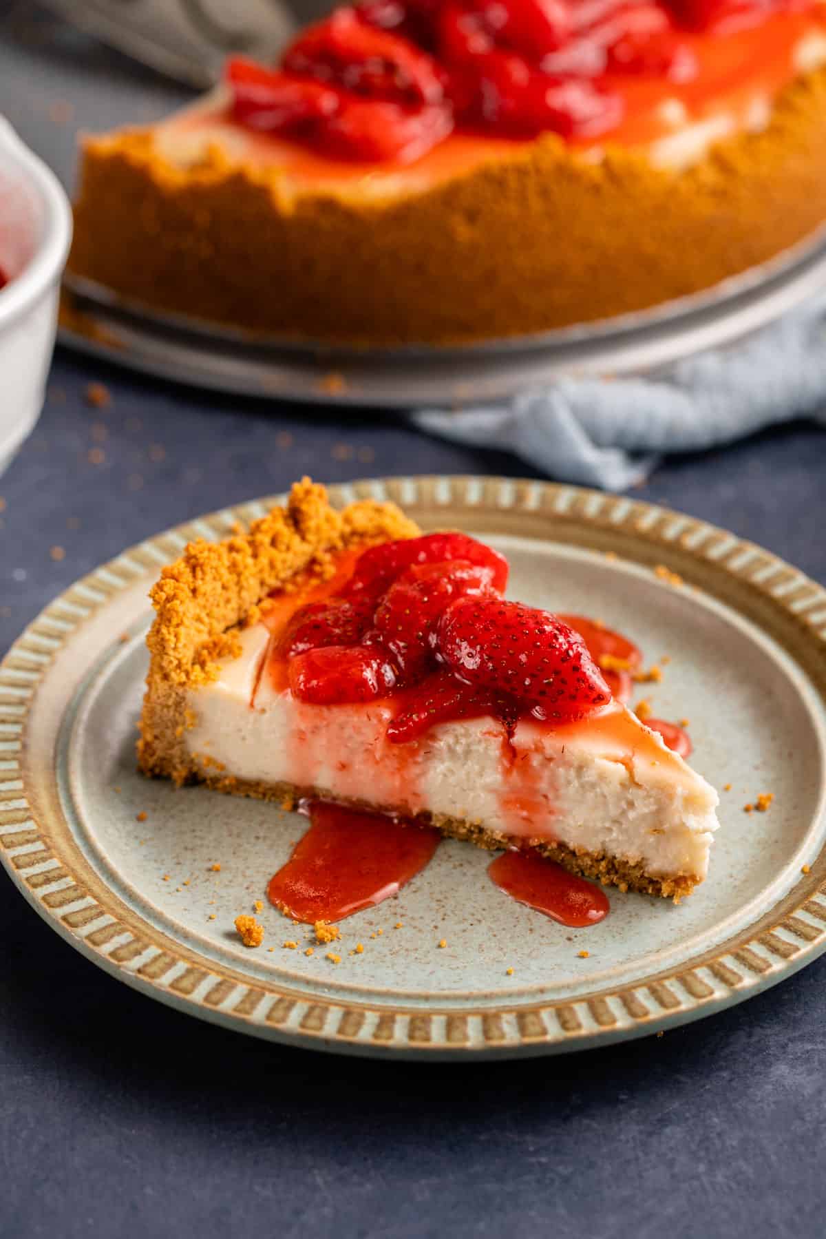 vegan cheesecake with strawberry sauce on light blue plate