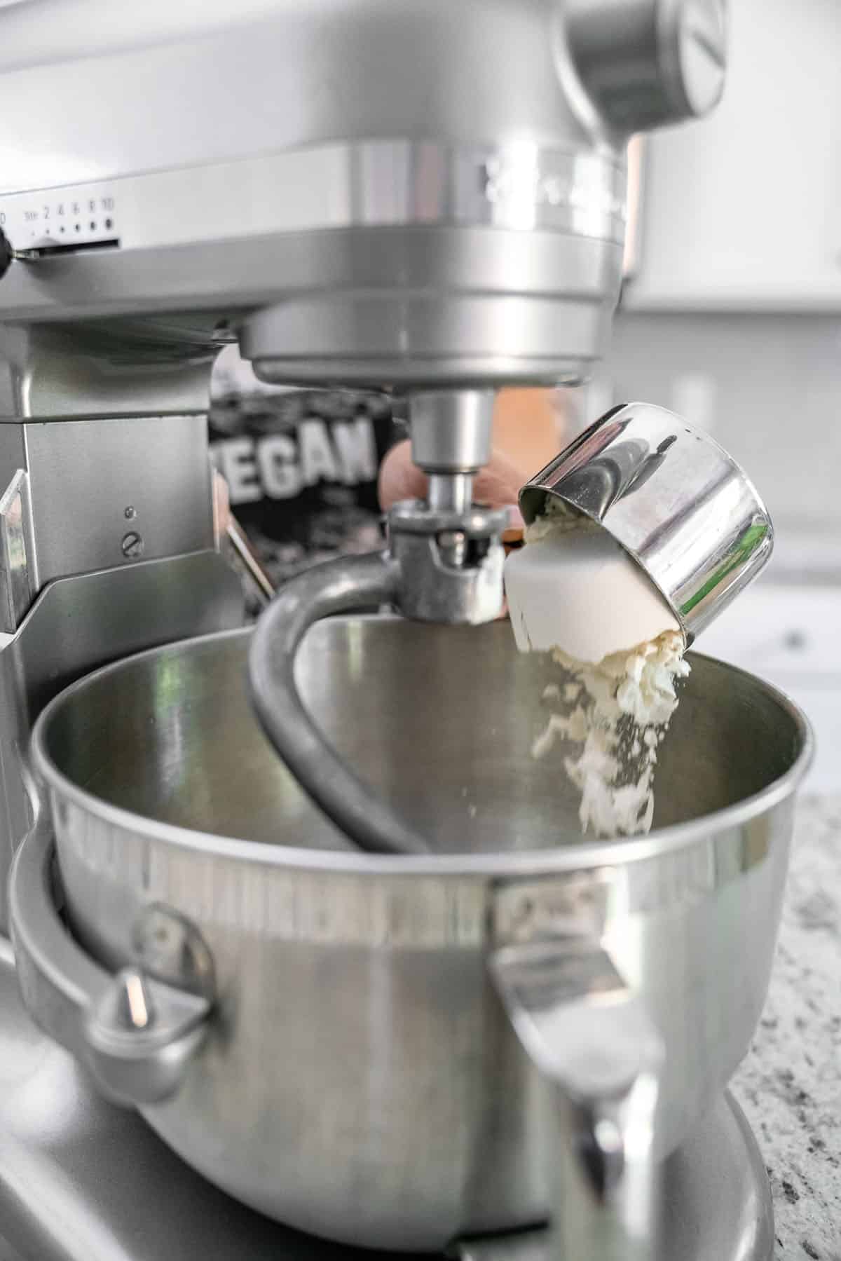 pouring flour into stainless steel standing mixer