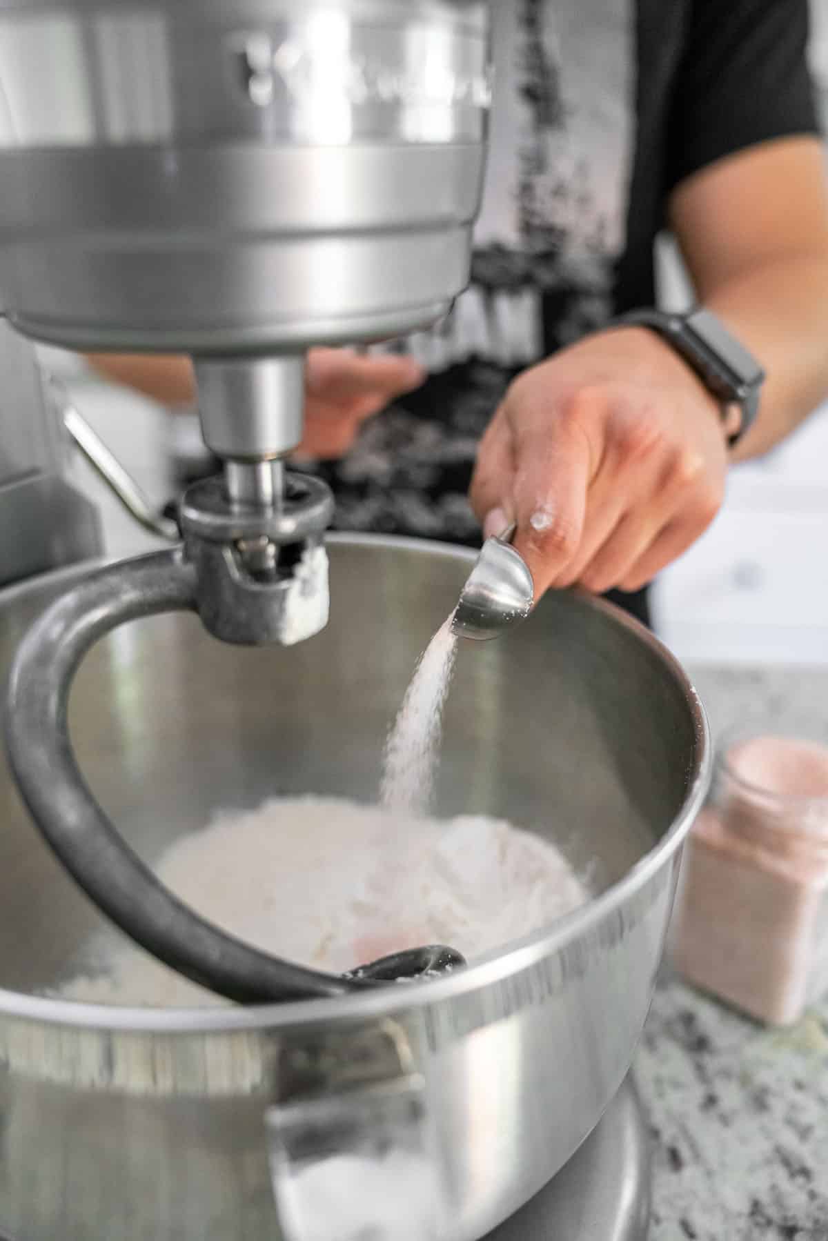 pouring salt into stainless steel standing mixer