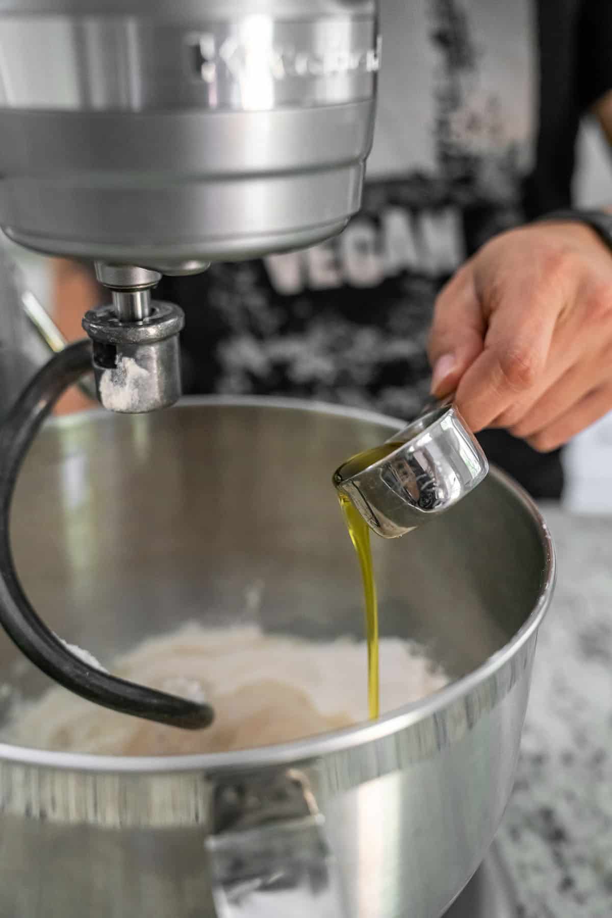 pouring oil into stainless steel standing mixer