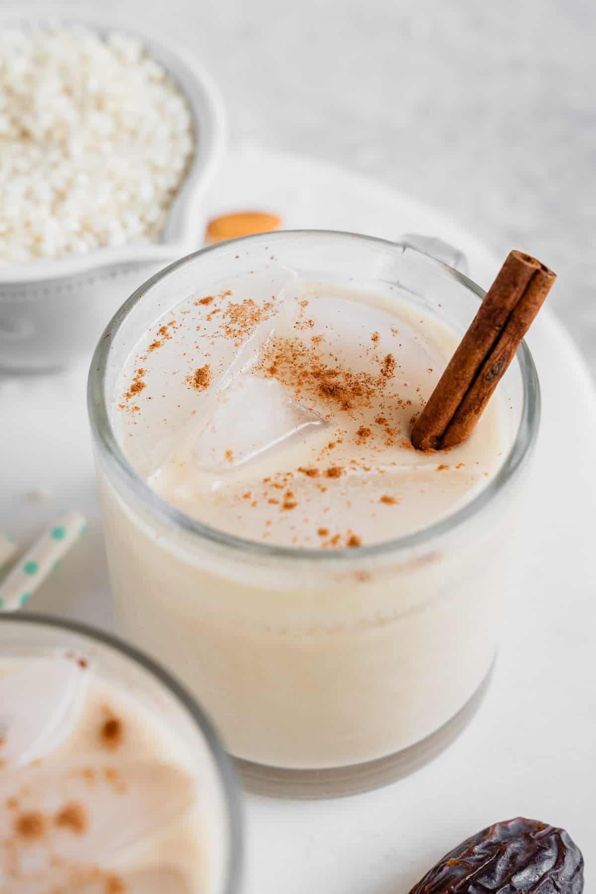 cloes up photo glass cups with date sweetened horchata and cinnamon sticks