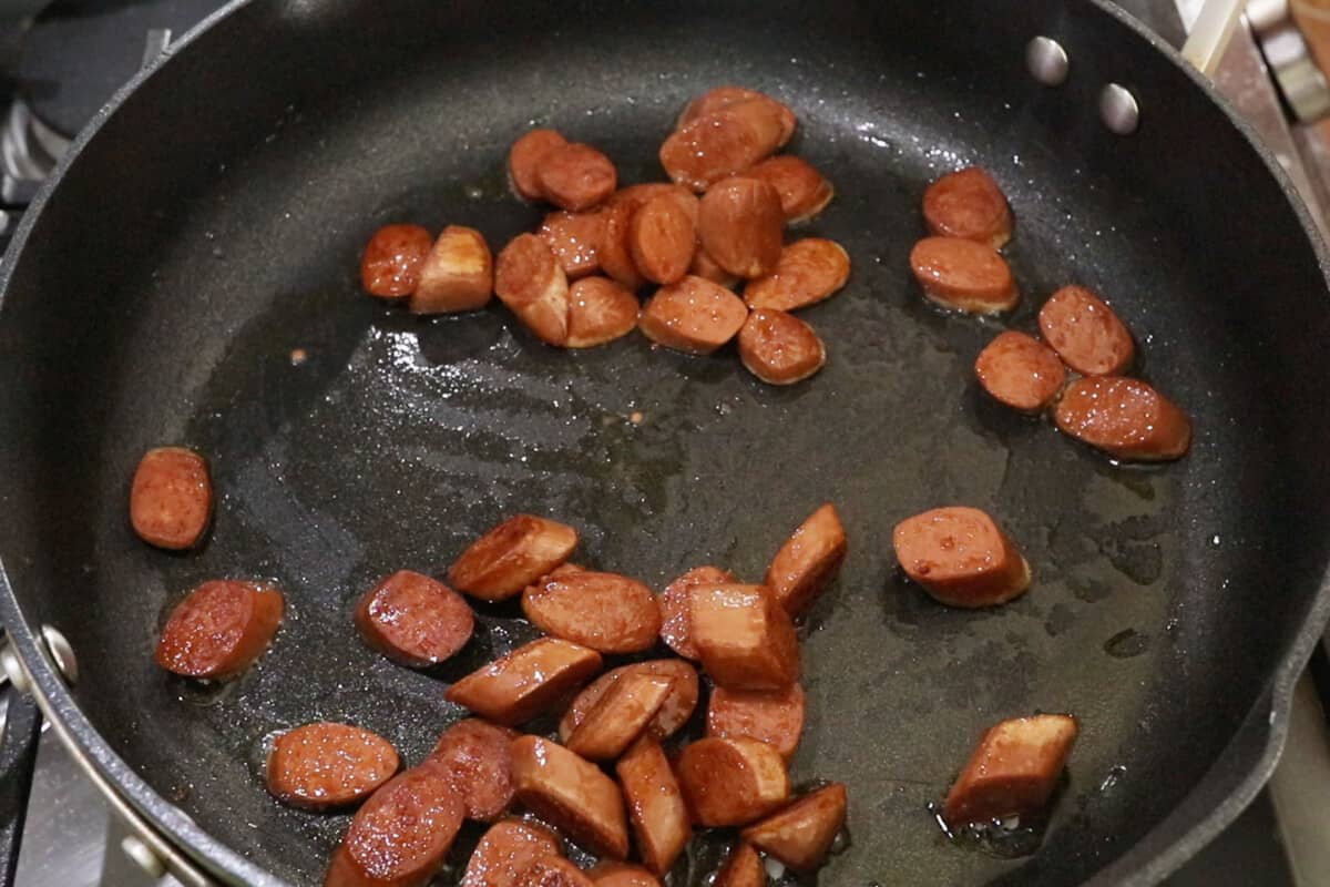 cooked sliced hot dogs in black pan