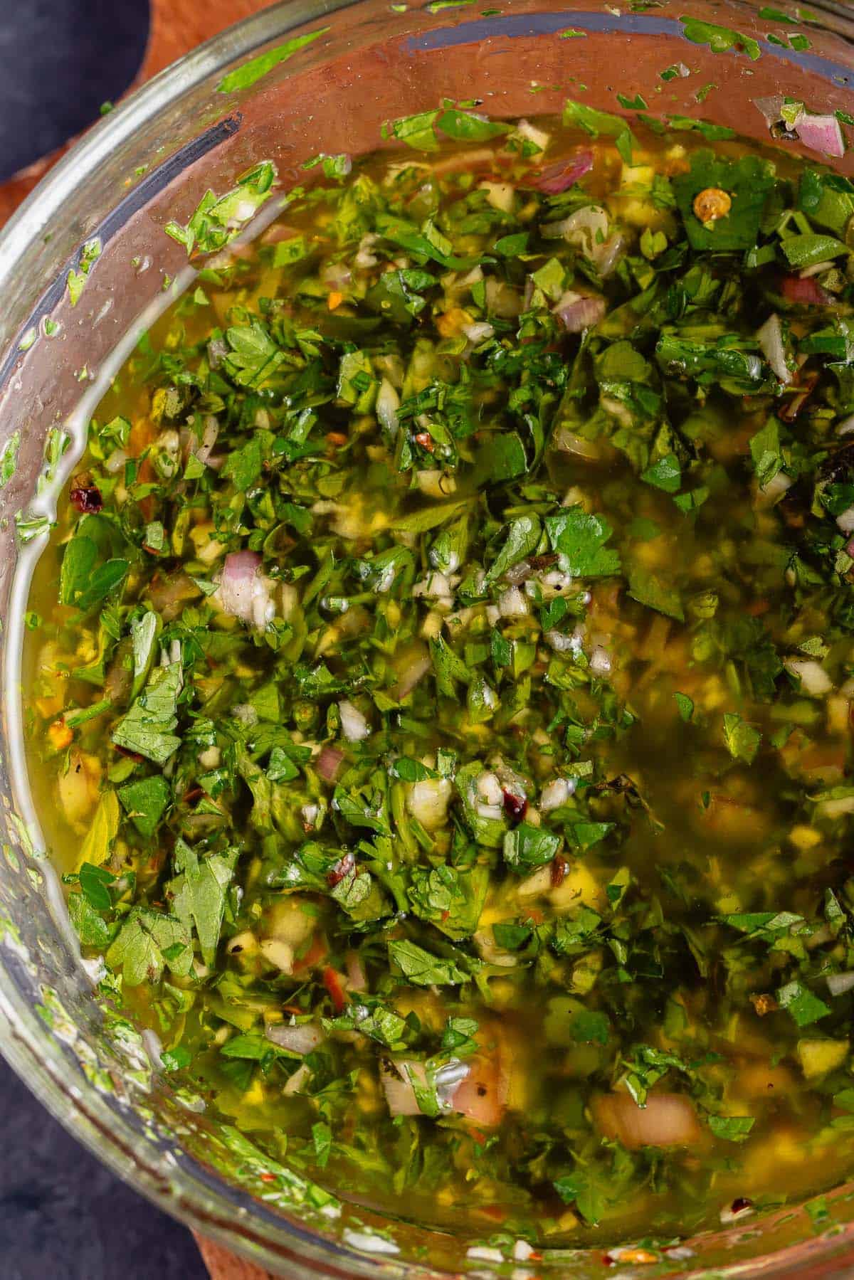 cloes up of fresh chimichurri sauce in glass bowl