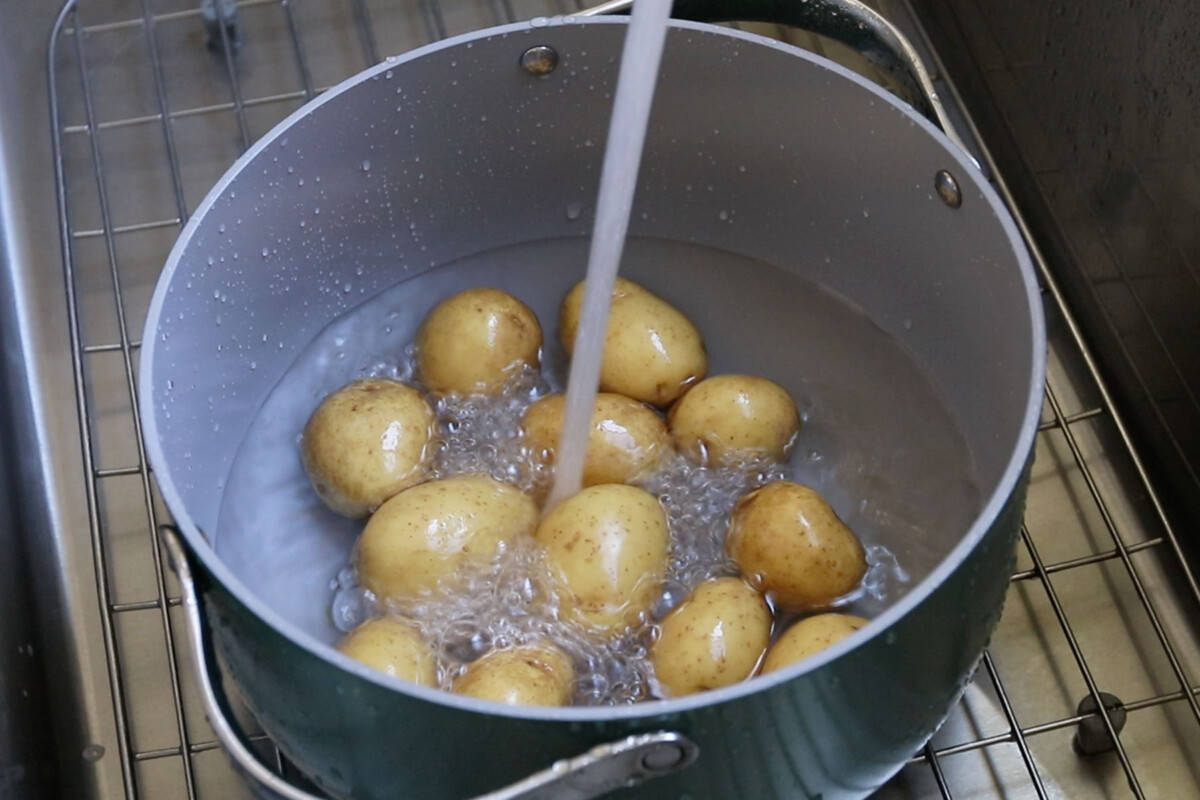 adding potatoes and water to large pot