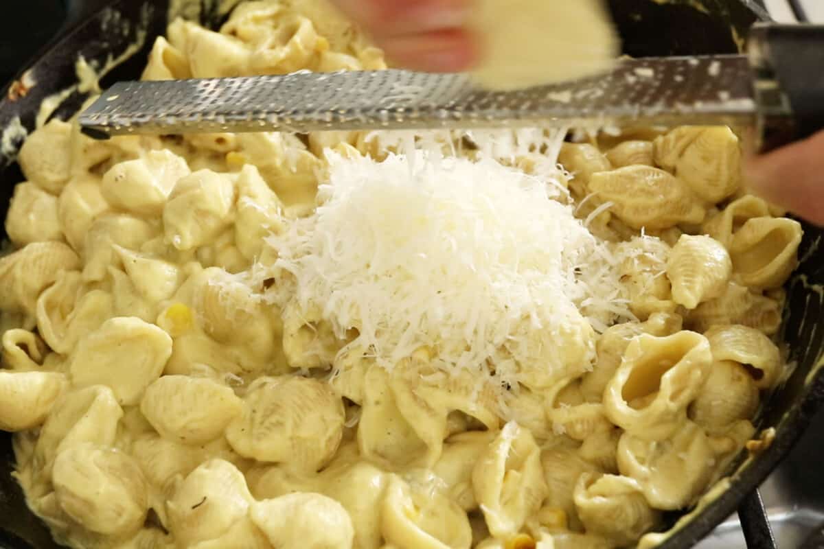 step by step image of parm getting grated into pasta