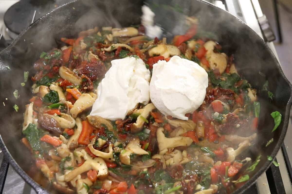 making sauce for Creamy Tuscan Vegan Chicken in cast iron skillet