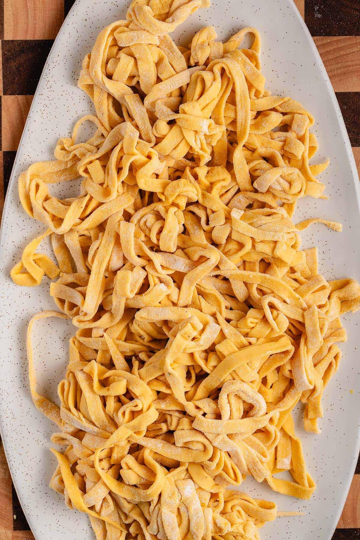uncooked Pumpkin Pasta with Sage Butter Sauce on white plate
