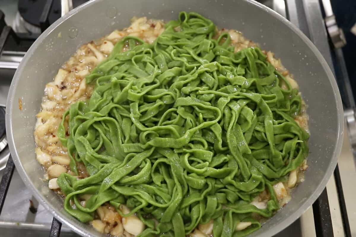 cooked spinach pasta in pan with sauce