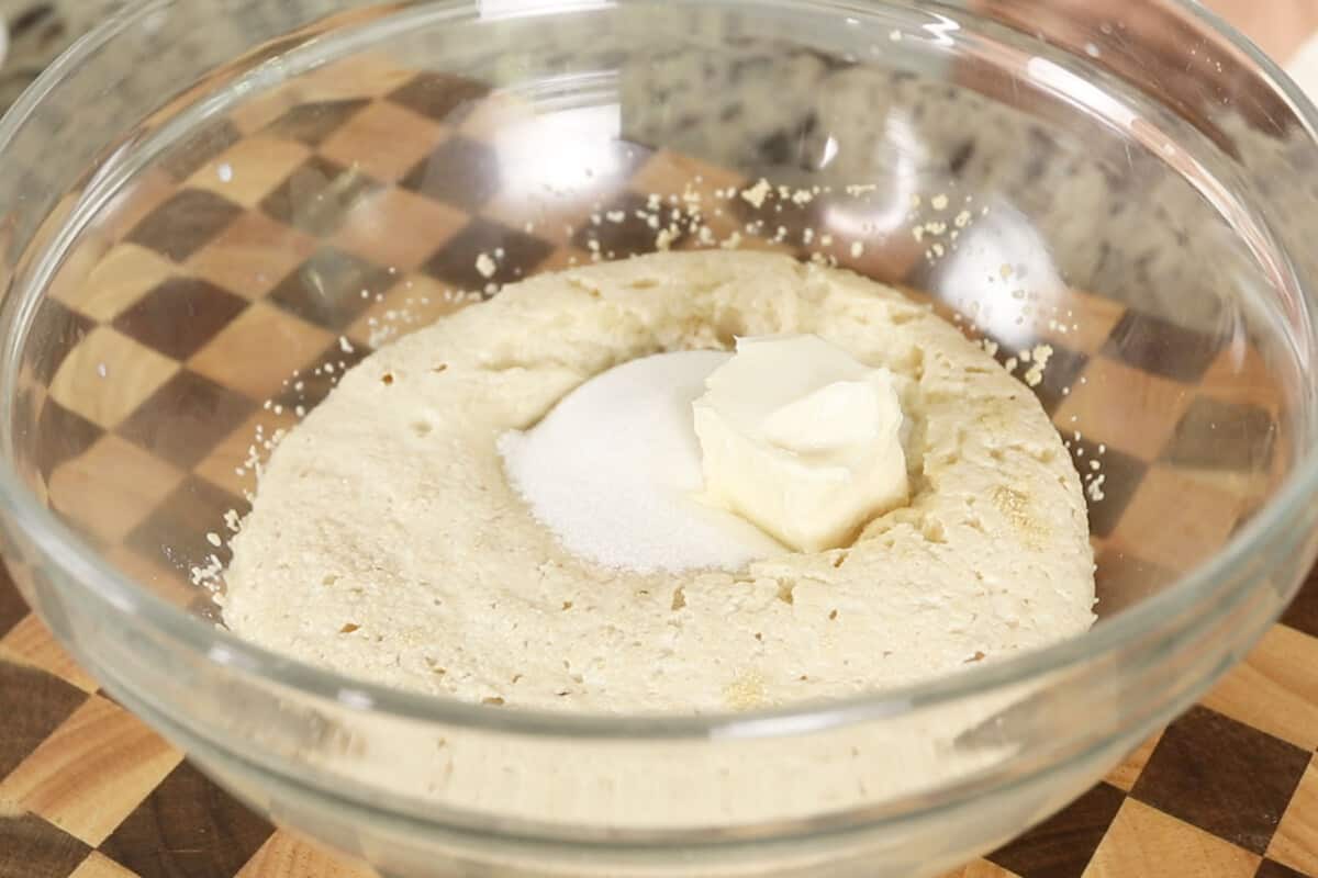 adding butter and sugar to bread dough