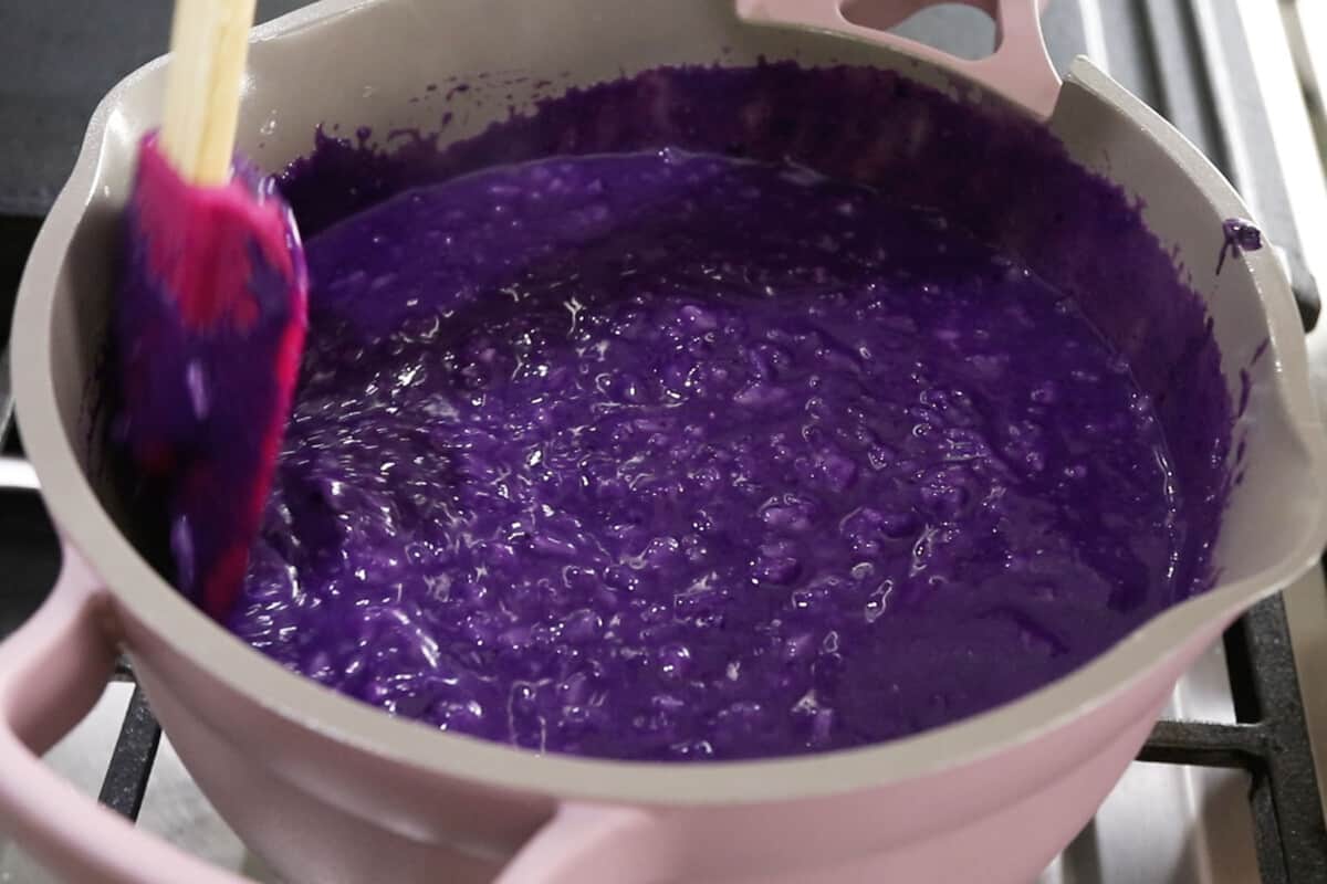 cooked ube champorado on stove in pink pot