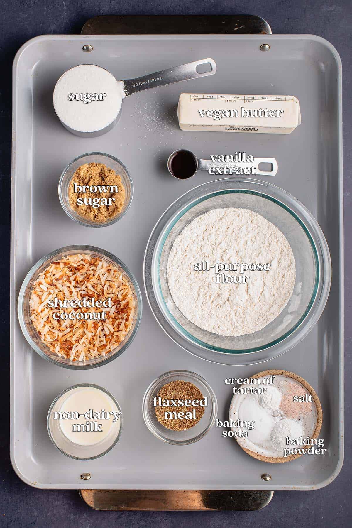 labeled ingredients for toasted coconut cookies on baking sheet