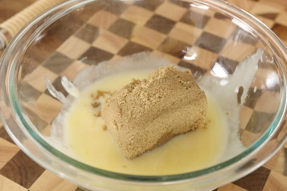 mixing brown sugar with melted butter in glass bowl
