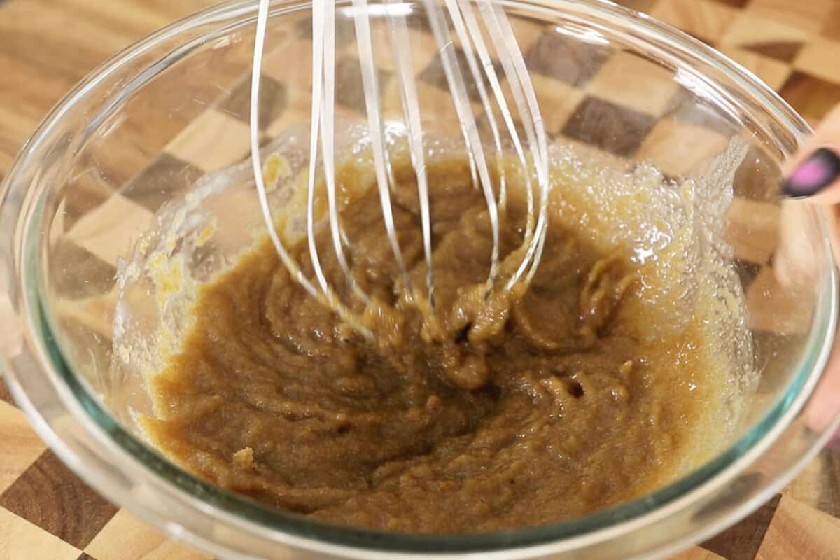 mixing brown sugar with melted butter in glass bowl