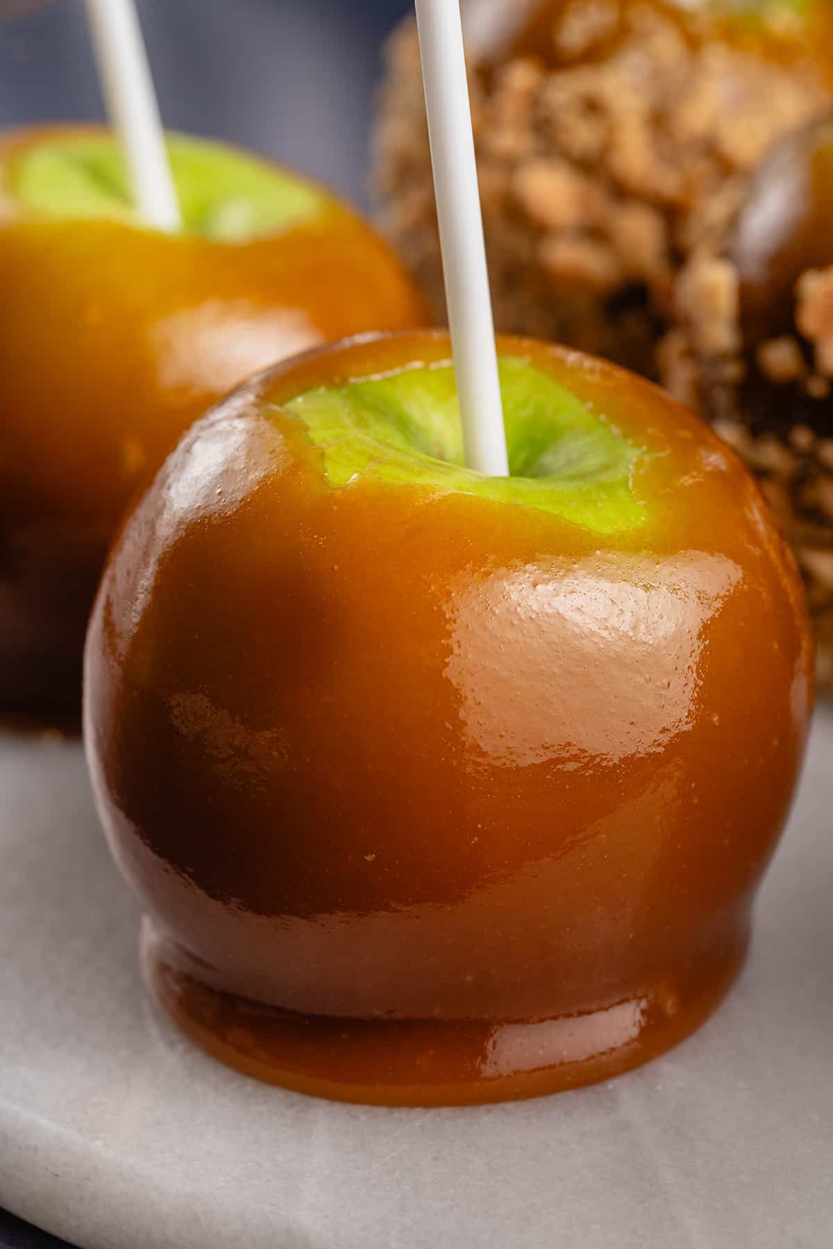 close up photo of vegan caramel apple with white stick