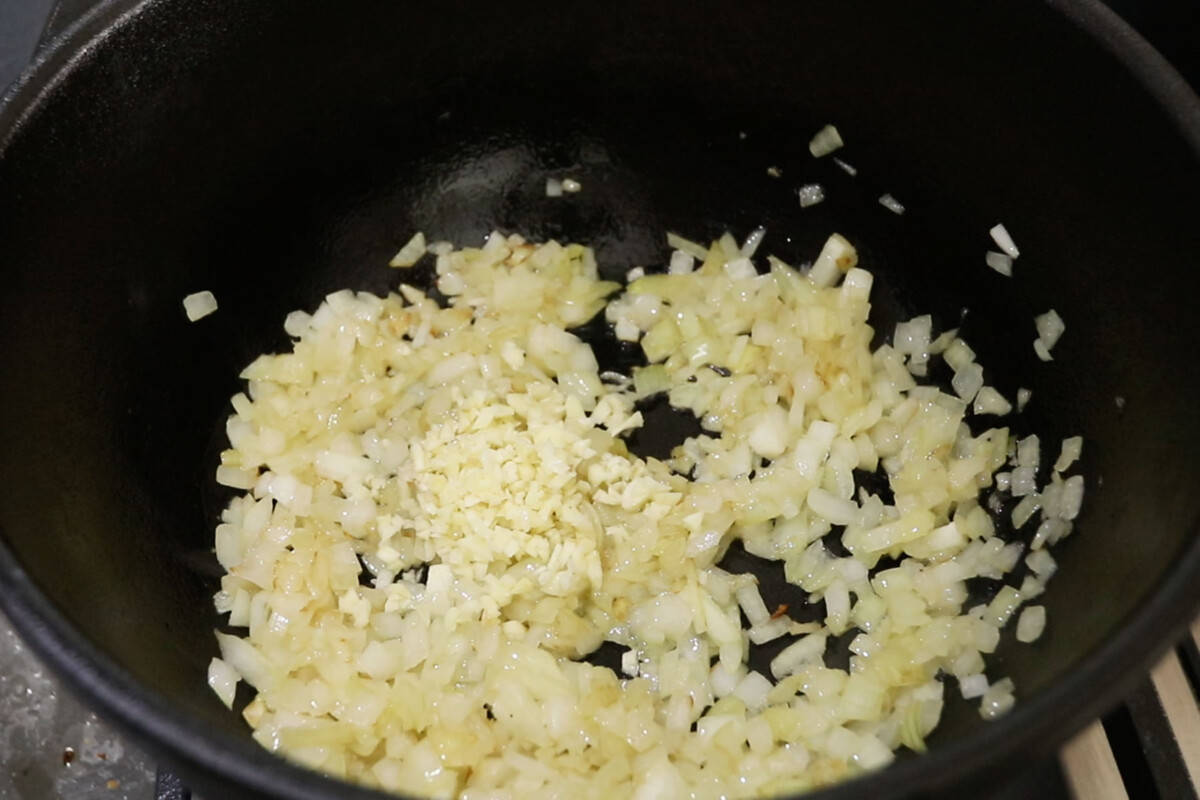 sauteeing onions and garlic in black pot