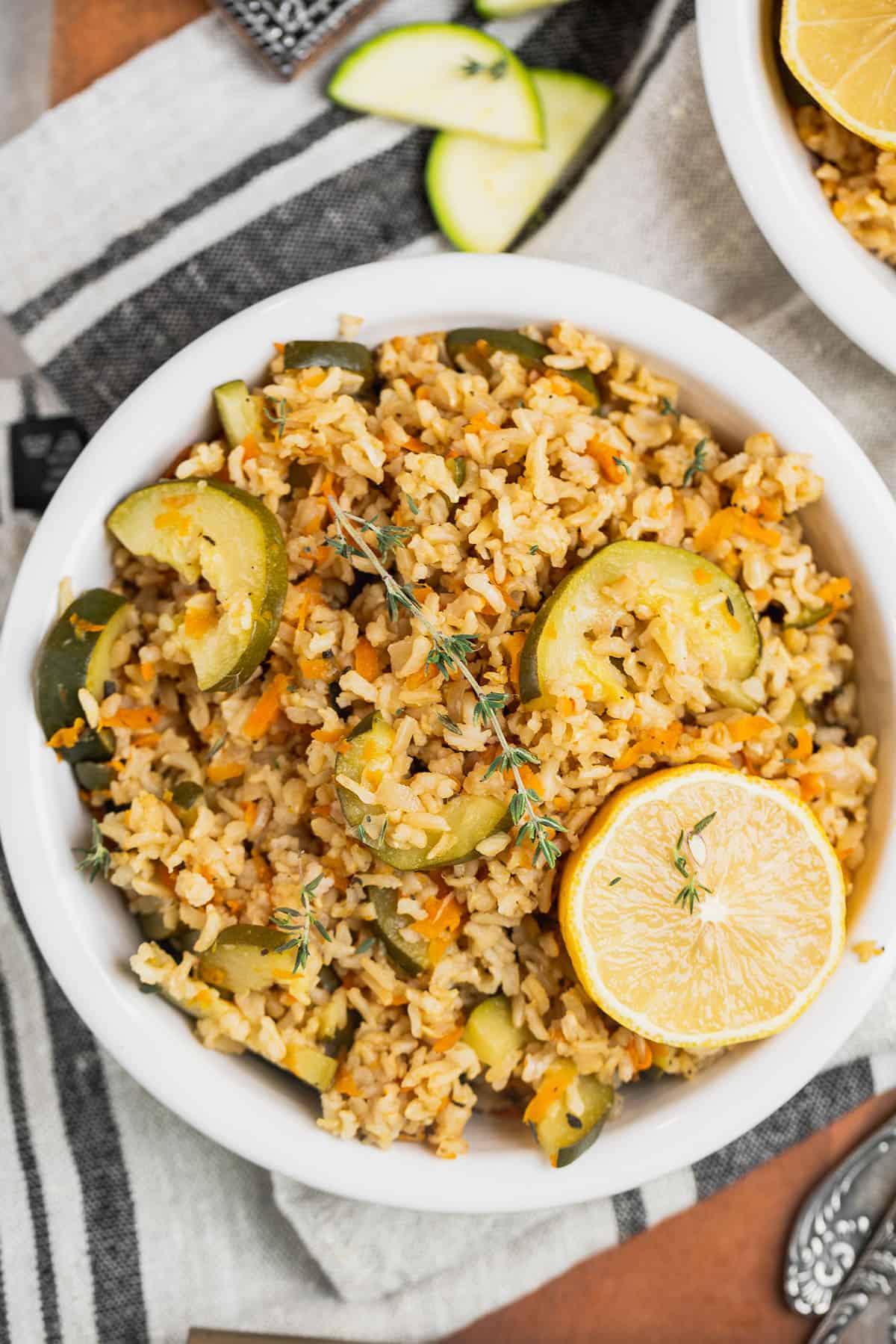 bowl of easy vegetable rice pilaf garnished with lemon and thyme on napkin