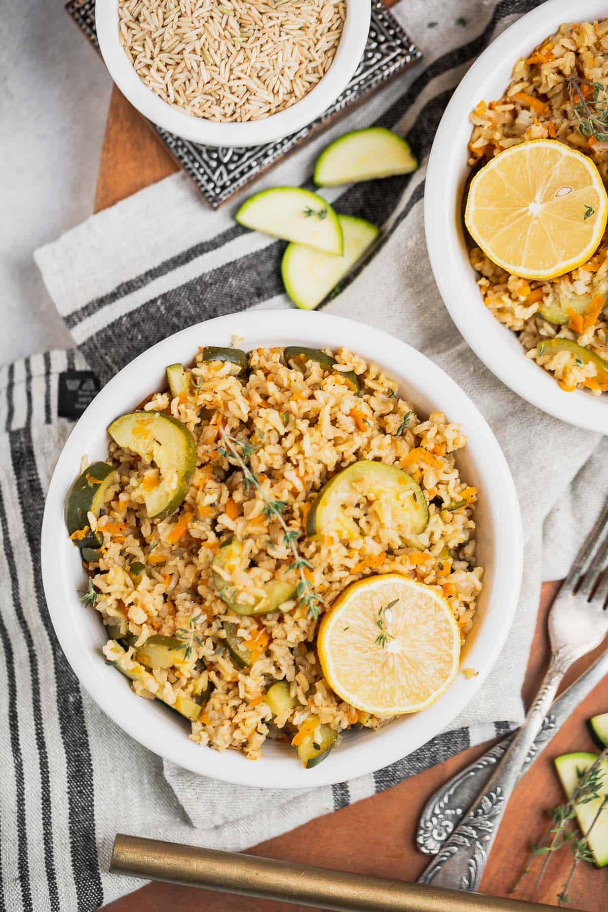 two bowls of vegetable rice pilaf under a decorative napkin