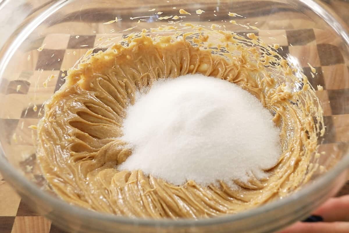 sugar being added to the butter and peanut butter