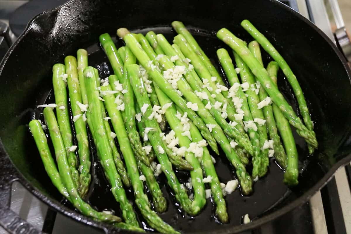 preparing simple pan fried asparagus in black pan