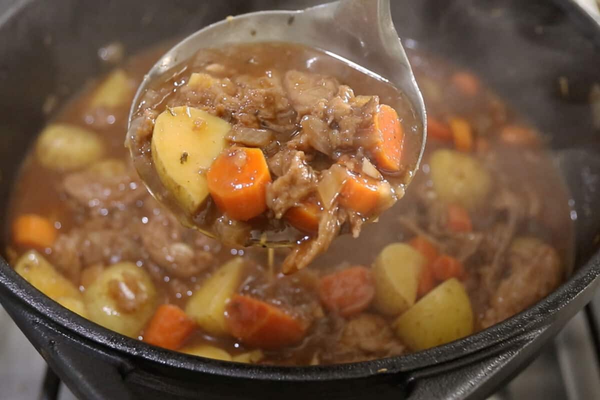 step by step - finished vegan beef stew scooped up with a big serving spoon