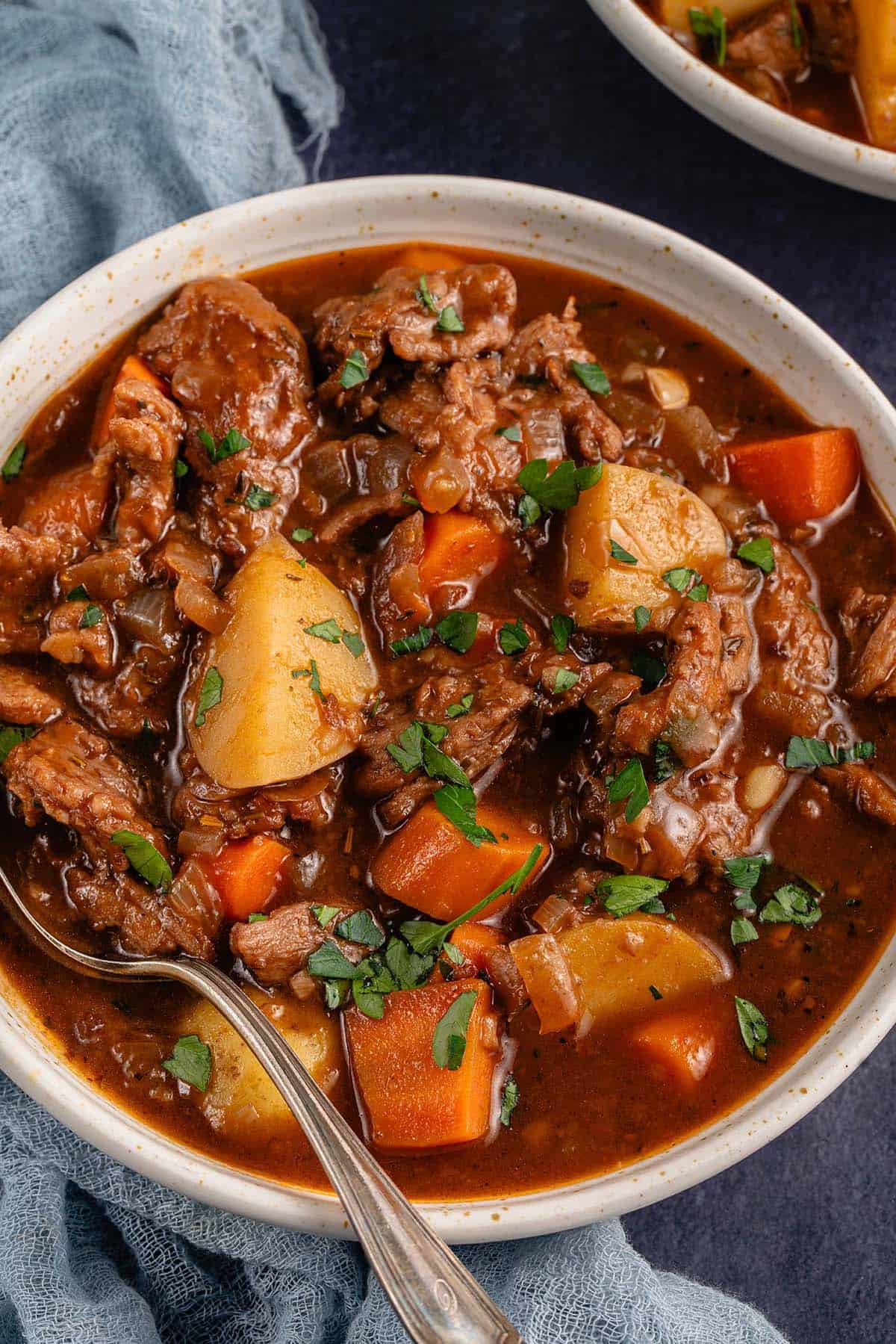 close up photo of a bowl of vegan beef stew with spoon