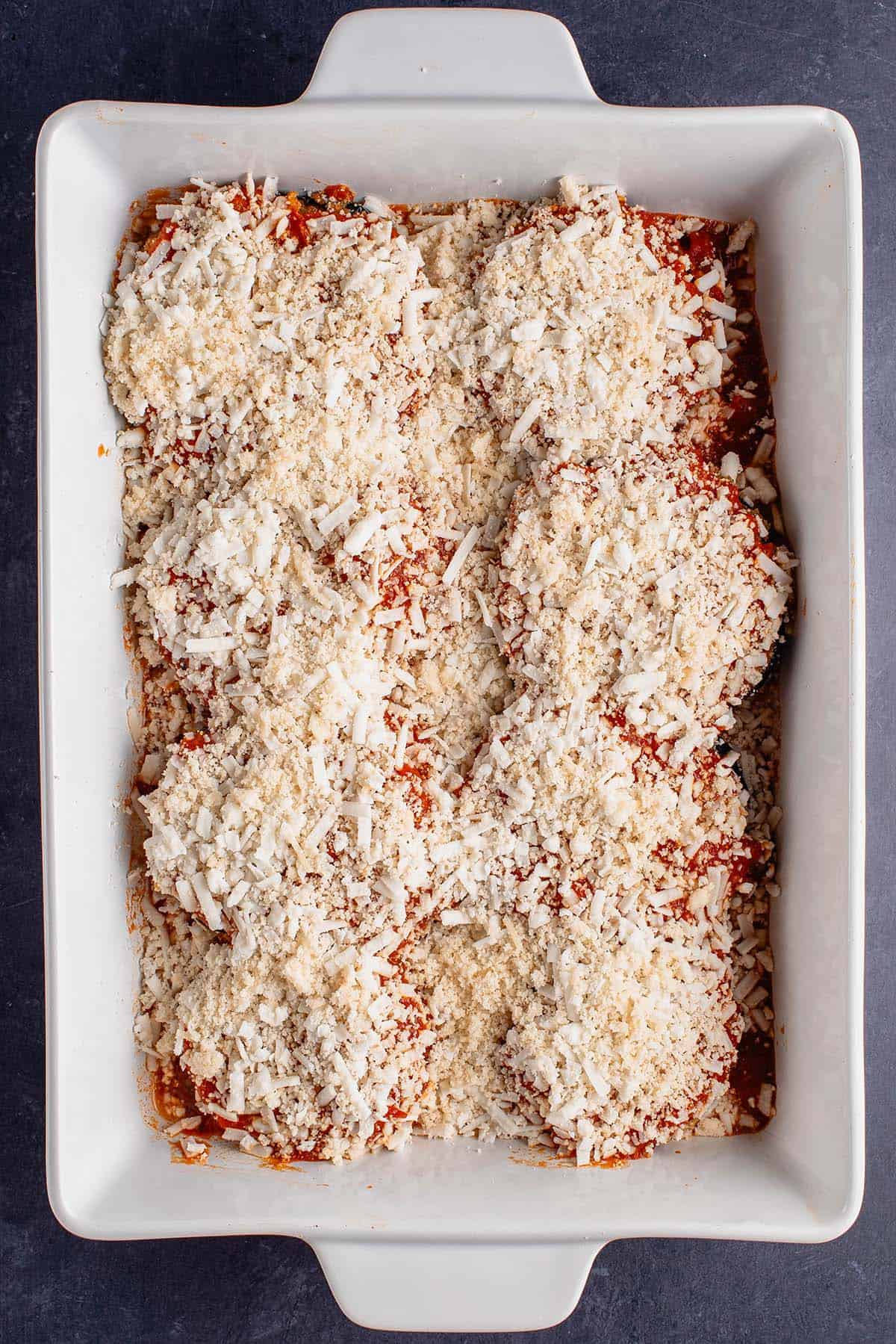 uncooked baking dish filled with eggplant parmesan