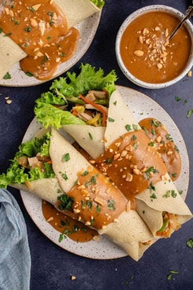 lumpiang sariwa covered in peanut sauce on a plate