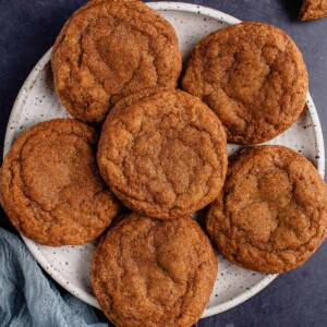 6 vegan pumpkin sugar cookies on white plate