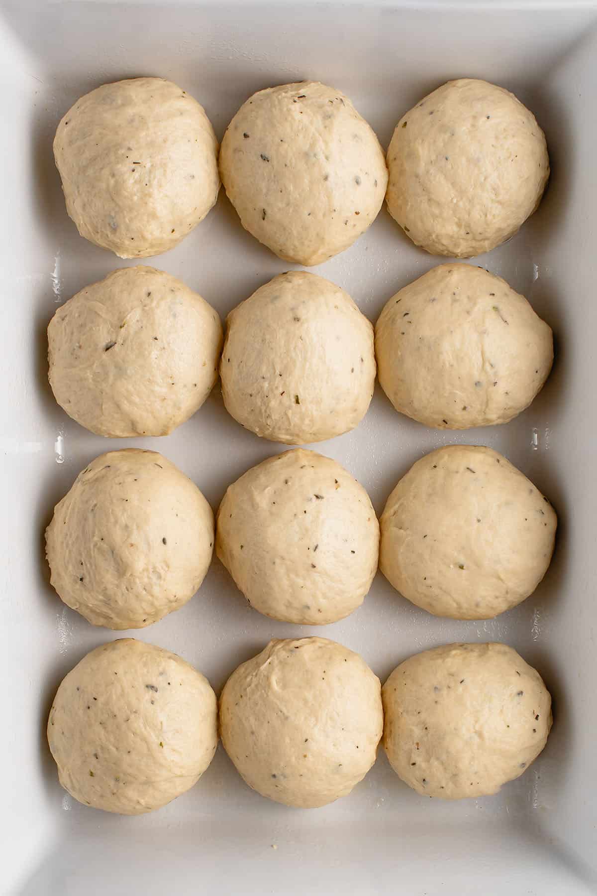 uncooked potato rolls in baking dish before rising