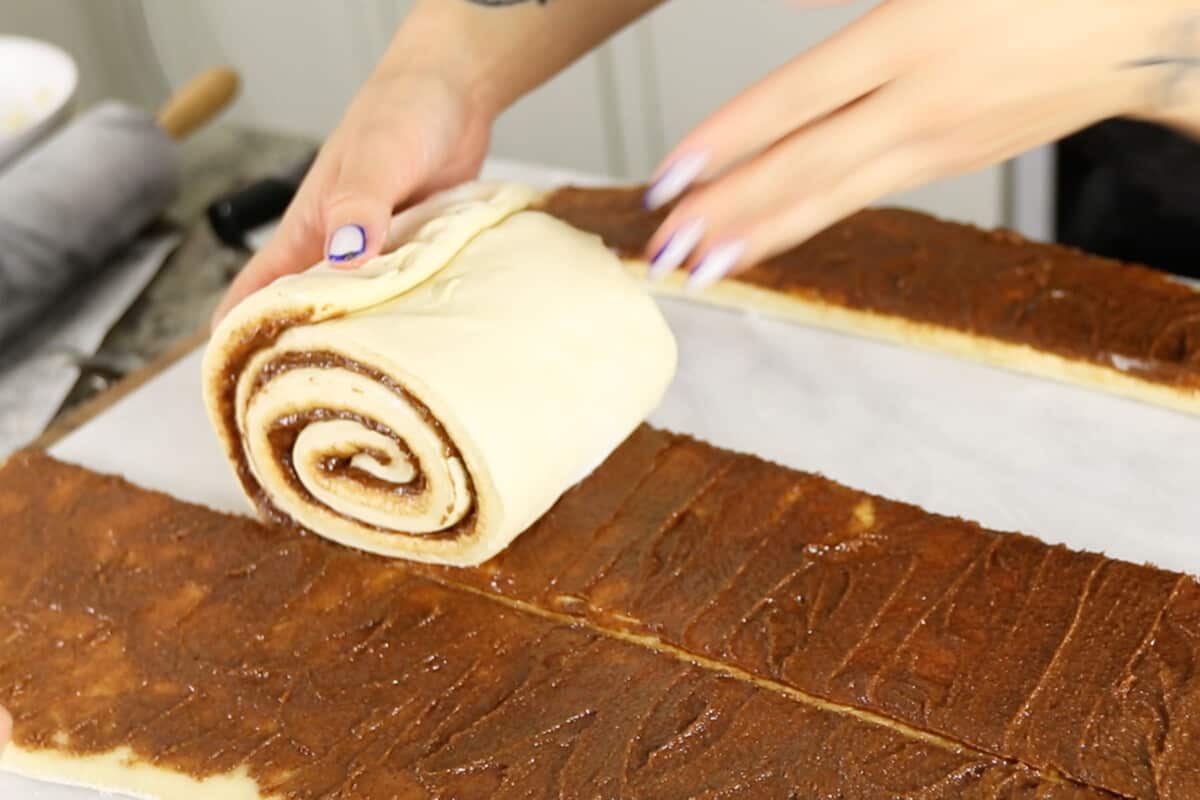 rolling dough into the giant cinnamon roll cake