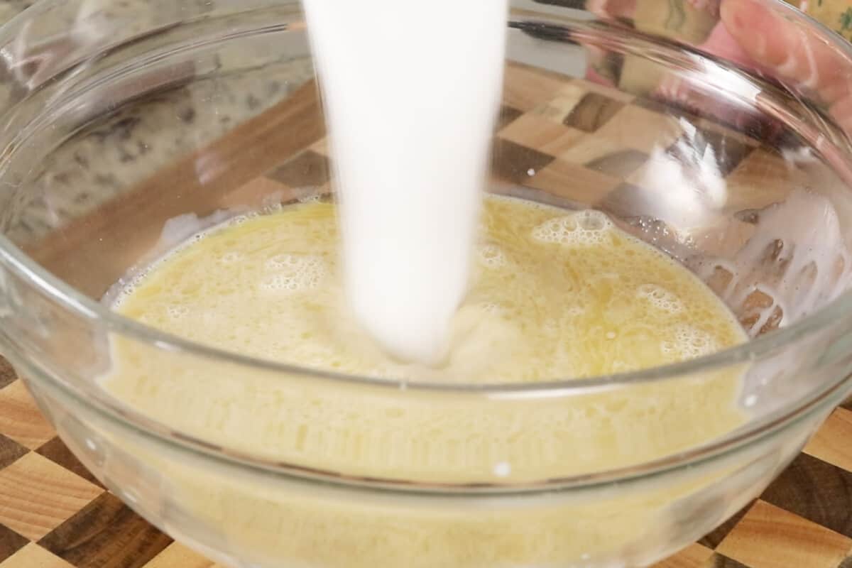 making ube cinnamon roll dough in glass bowl
