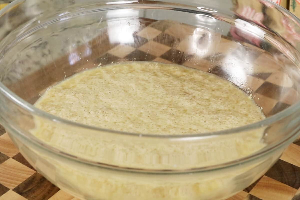 making ube cinnamon roll dough in glass bowl